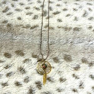 Gold dreamcatcher necklace featuring dangle heart and leaf